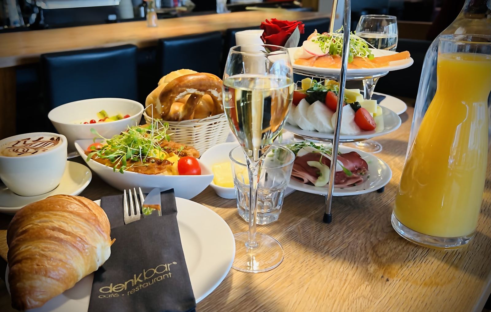 Gedeckter Brunch-Tisch mit Croissants, Etagere, Orangensaft und Frizzante