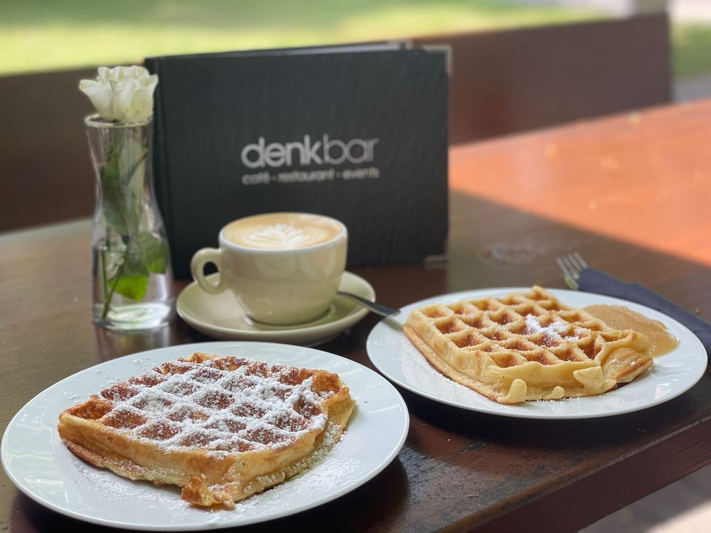 Frische Waffeln mit Puderzucker und eine Tasse Kaffee